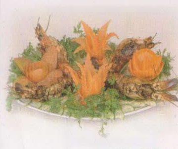 A garnished seafood platter with carved vegetable flowers