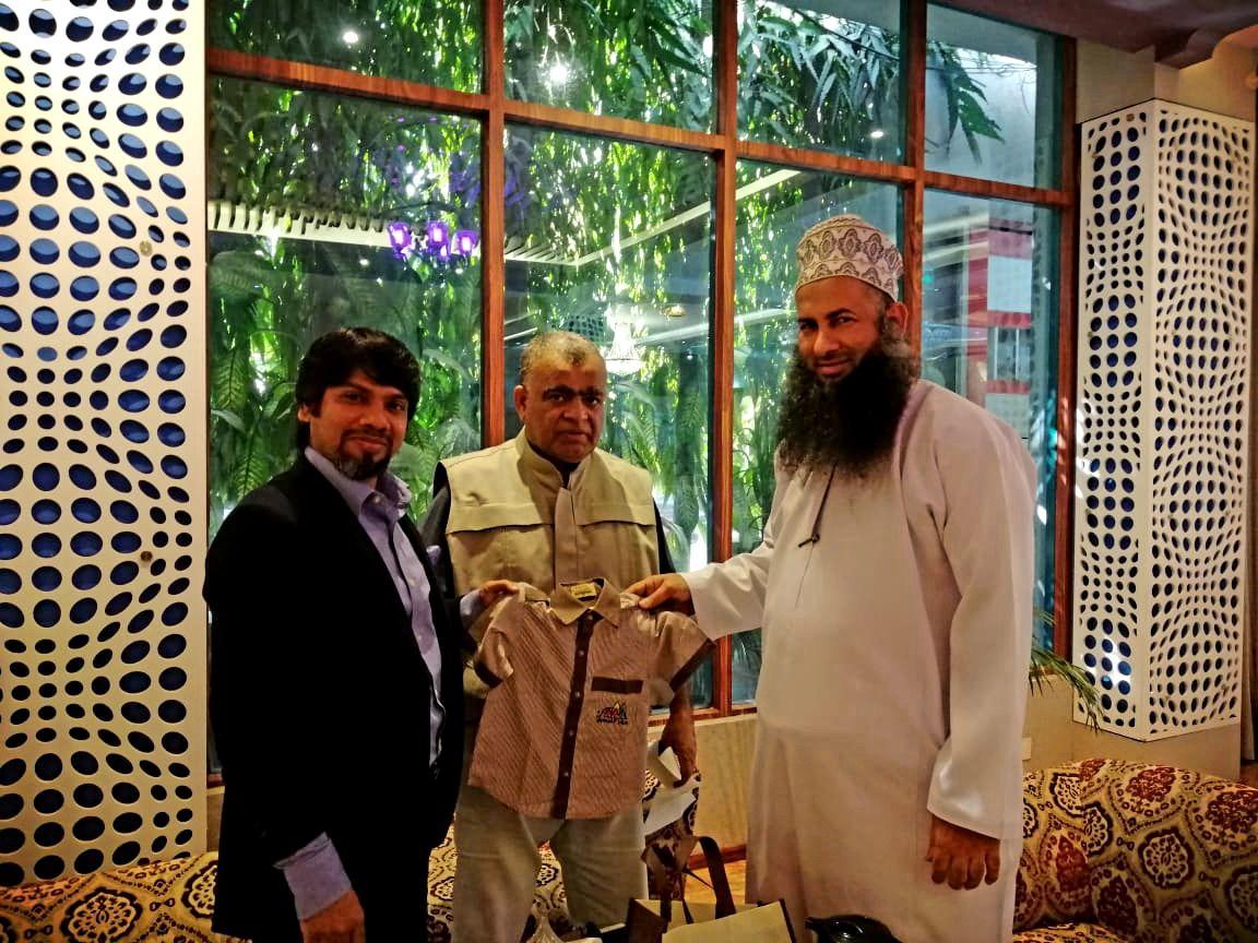Visiting buyers holding a children's garment sample