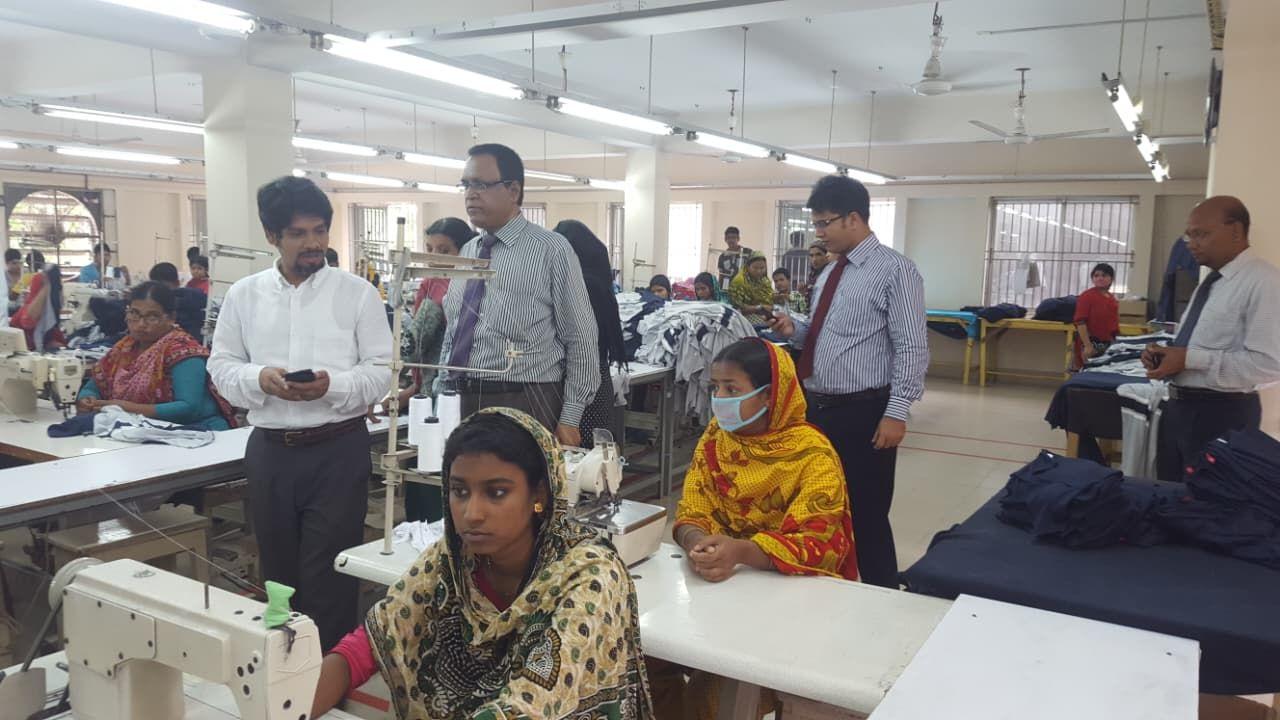 Visiting buyers with Rahtex management behind operators on a sewing floor