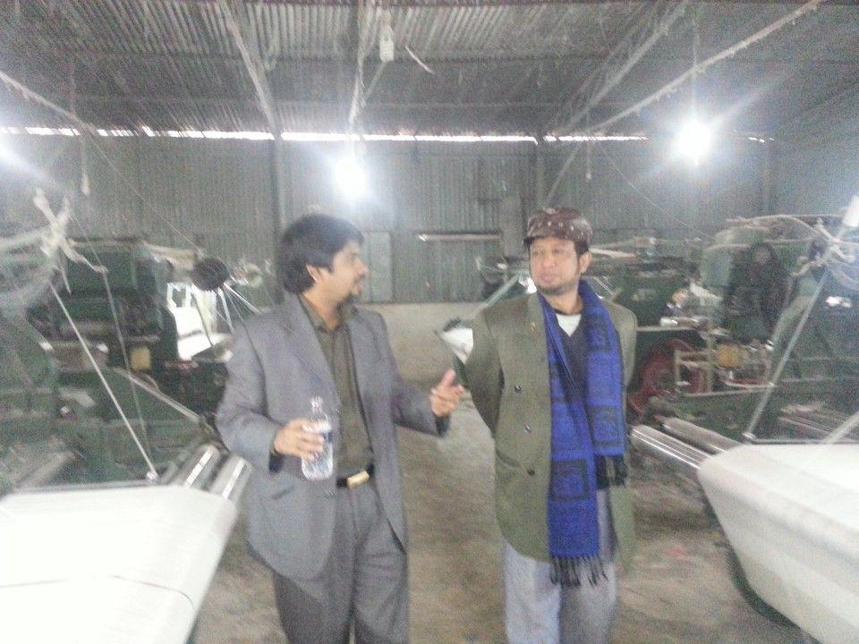 The Chairman with a visitor among the looms of the weaving unit